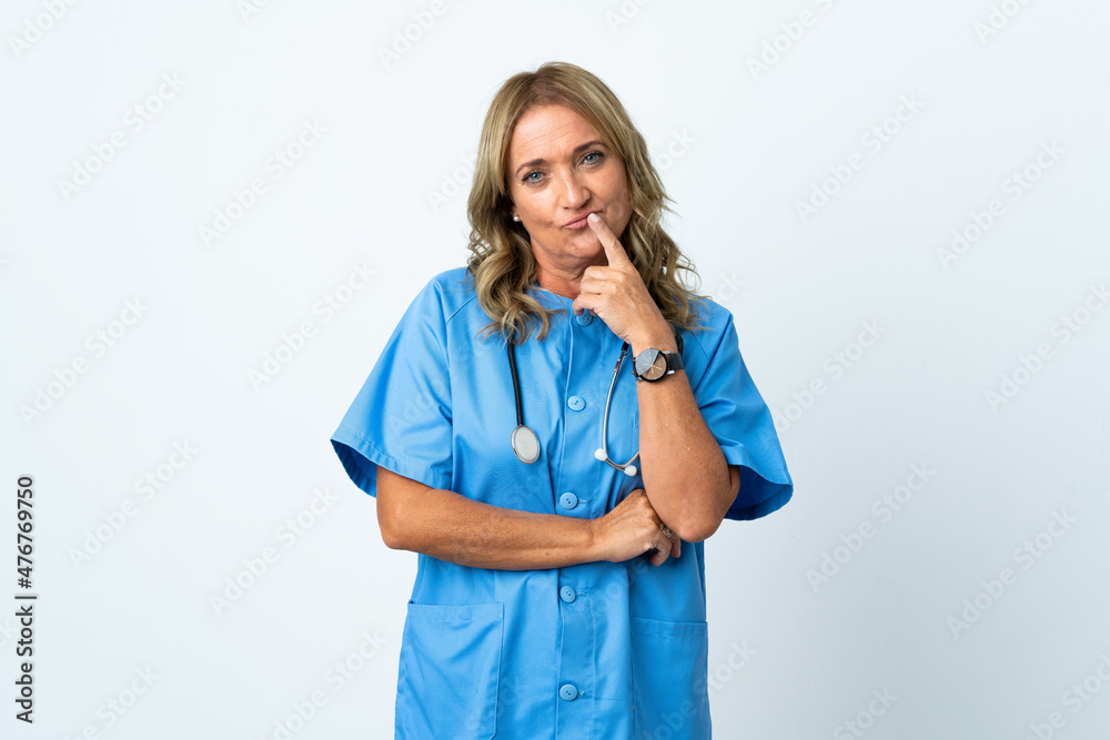 Middle aged surgeon woman over isolated background having doubts while looking up Middle aged surgeon woman over isolated background having doubts while looking up