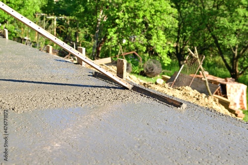 Leveling concrete with a wooden tool on a construction site