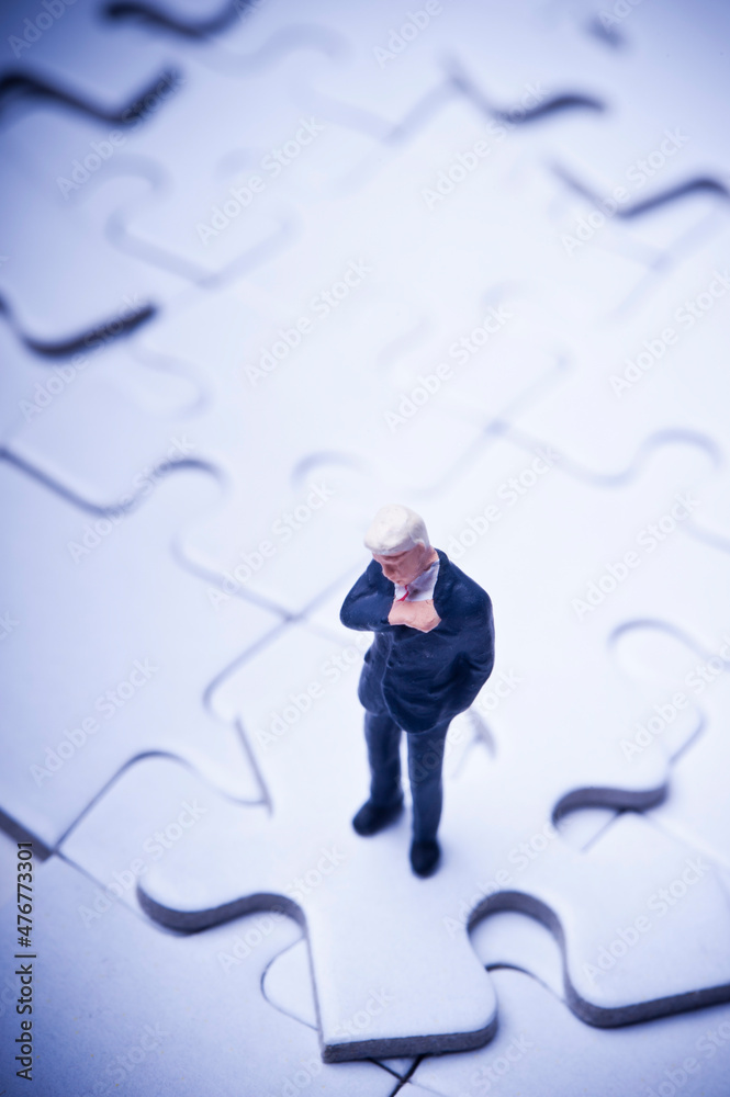 miniature figurine of a businessman standing on a jigsaw puzzle with a missing piece, concept for problem solving and management critical decisions miniature figurine of a businessman standing on a jigsaw puzzle with a missing piece, concept for problem solving and management critical decisions