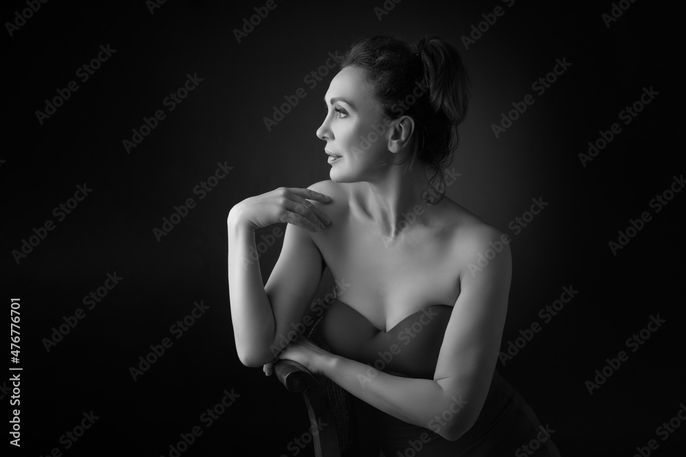 Portrait of a sensual fifty year old woman on grey studio background. Monochrome shot. Portrait of a sensual fifty year old woman on grey studio background. Monochrome shot.