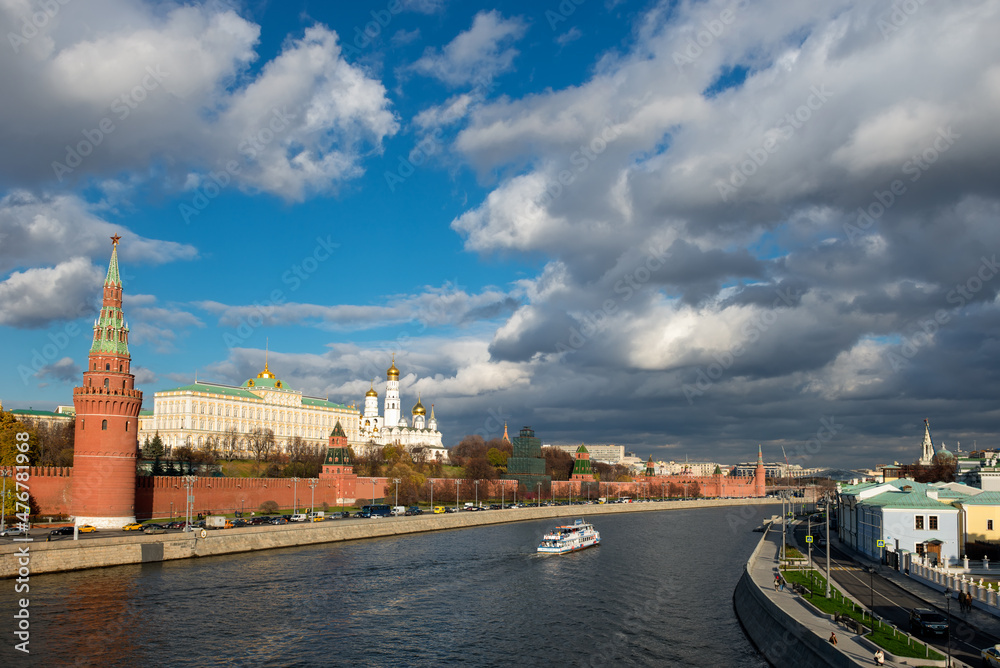 View of the Moscow Kremlin and pleasure cruise ship on the Moscow River on a autumn day View of the Moscow Kremlin and pleasure cruise ship on the Moscow River on a autumn day