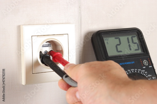 Measuring the voltage in an electrical outlet using a multimeter.