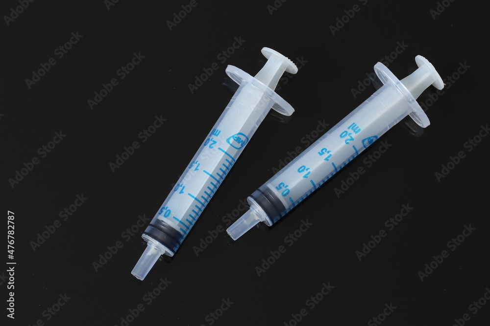 Medical plastic disposable syringe on a black background. Medical syringe. Medical plastic disposable syringe on a black background. Medical syringe.