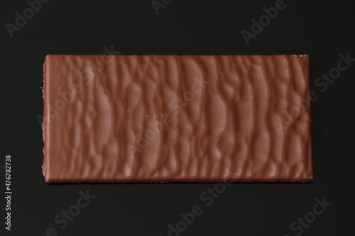 Milk chocolate with coconut filling on a black background. Milk chocolate. 