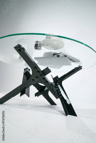 Glass table with metal legs on rivets. Bottom view. White background