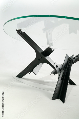 Glass table with metal legs on rivets. Bottom view. White background
