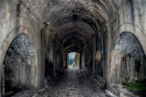 Arched entrance to Rozafa Castle in Shkodra  Albania. Old stone tunnel with a gate at the end - inside view