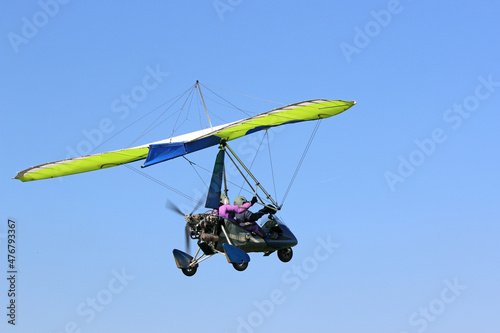 Fotografia Ultralight airplane flying in a blue sky