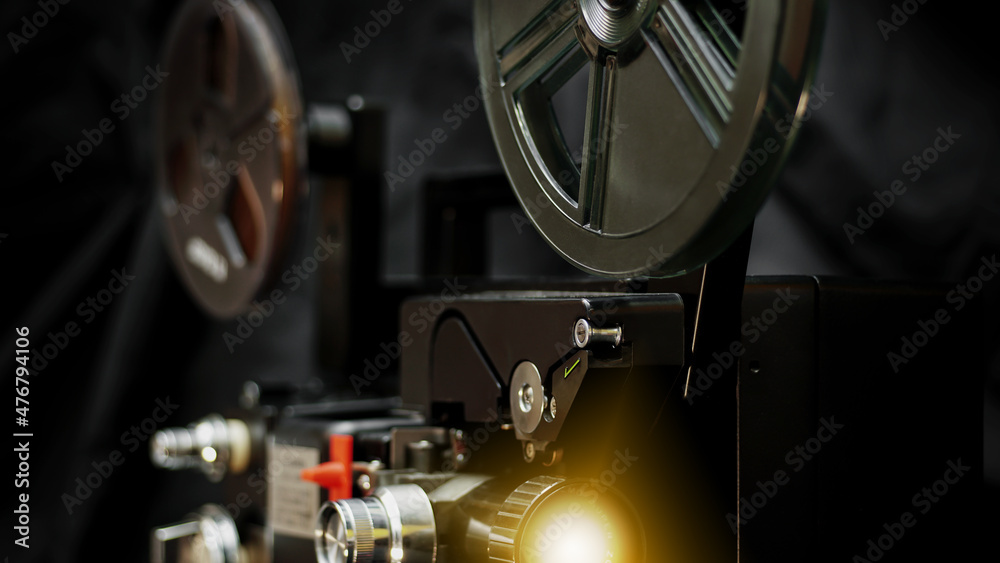 8 mm movie projector on dark background with beam.	