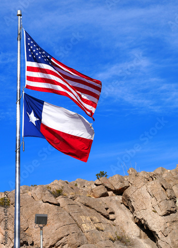 Flags of the USA and Texas flying on a mast