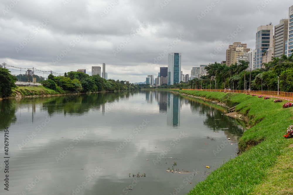 polluted Pinheiros river in Sao Paulo, Brazil. bike lane and buildings cityscape
