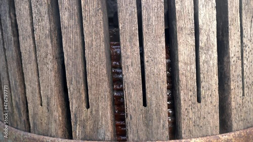 Apples in an cider press and juice dripping down. Fresh apples in drawer of wooden squeezer for squeezing natural juice to produce in village. Fruit packaging warehouse. Food processing 4k