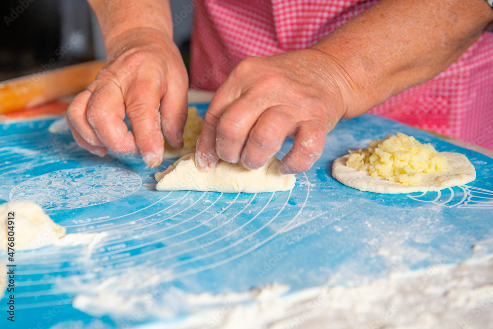 mom makes pies with potatoes out of dough. High quality photo mom makes pies with potatoes out of dough. High quality photo