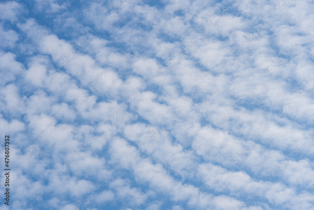 White cirrocumulus clouds against a blue sky, background.. - obrazy, fototapety, plakaty 