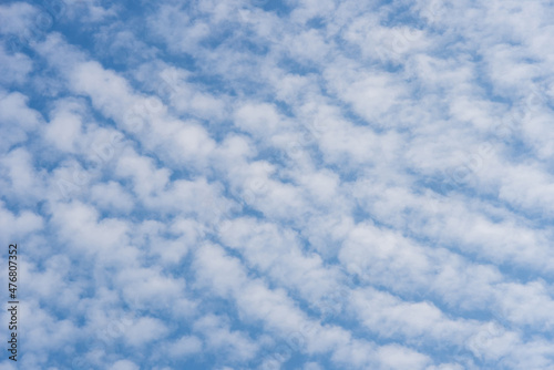 White cirrocumulus clouds against a blue sky, background.. photo