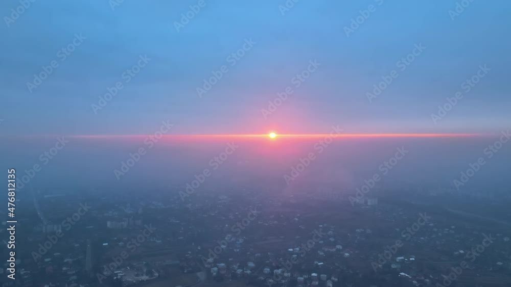 Aerial view from airplane window at high altitude of earth covered with white thin layer of misty haze and distant clouds at sunset Aerial view from airplane window at high altitude of earth covered with white thin layer of misty haze and distant clouds at sunset