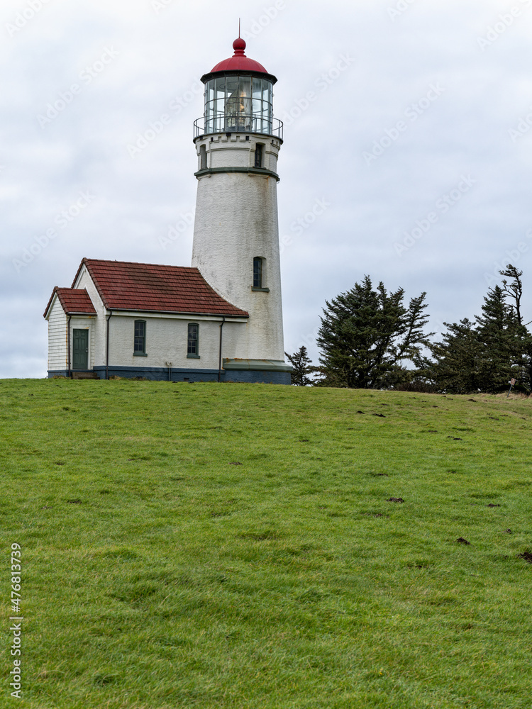 Lush green grass surrounds the lighthouse at Cape Blanco State Park, Oregon, USA