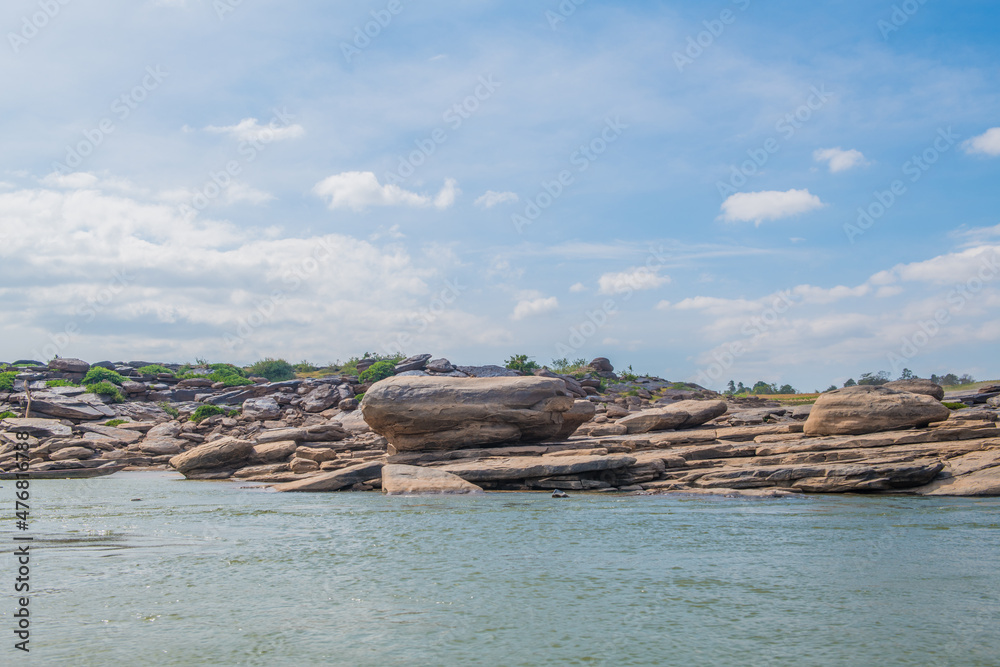 view from the boat: Rocks on both sides of the Mekong River