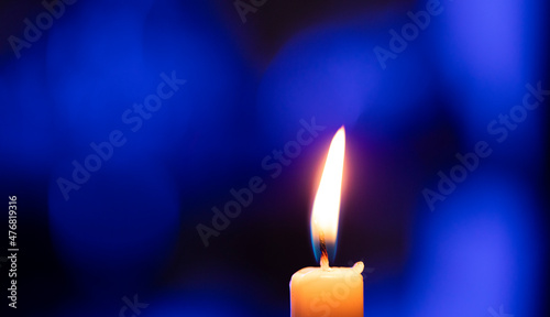 burning candle on black background. Blue background. Light. Candle. 