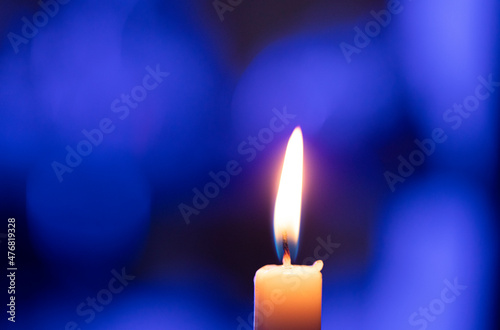 burning candle on dark background