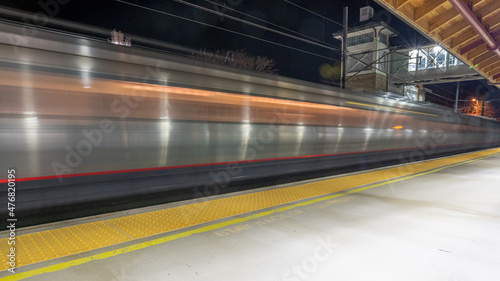 High-speed train going through a station at night. Motion blur transportation concept.