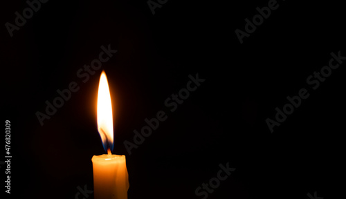 burning candle on black background