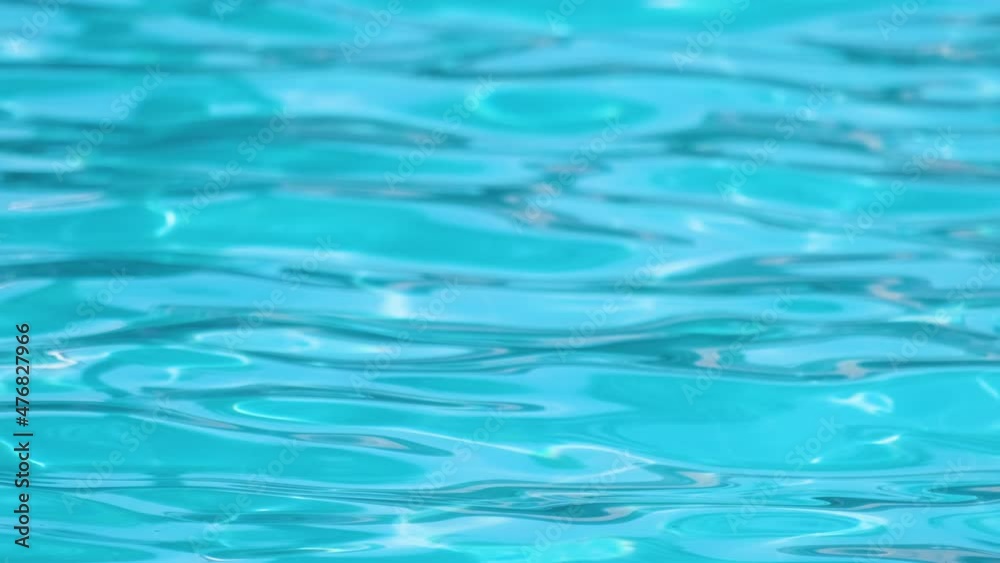 Closeup surface of blue clear water with small ripple waves in swimming pool Closeup surface of blue clear water with small ripple waves in swimming pool