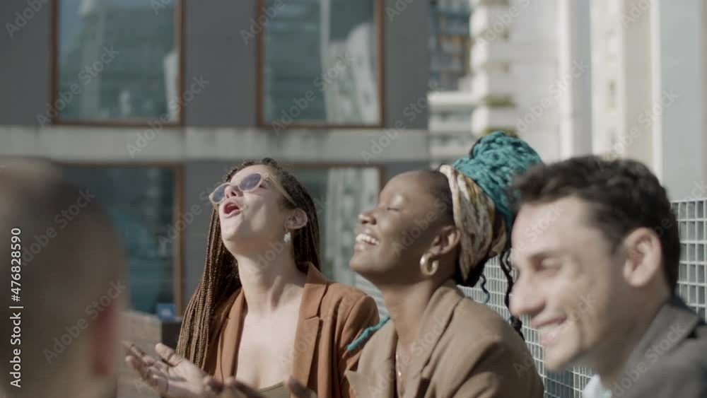 Medium shot of happy business partners laughing together outdoor. Side view of excited coworkers spending good time together, having business party on rooftop on summer day. Friendship, joy concept Medium shot of happy business partners laughing together outdoor. Side view of excited coworkers spending good time together, having business party on rooftop on summer day. Friendship, joy concept