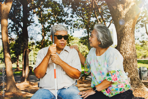 Photos Senior couple caring for blind lovers concept : Happy senior wife was beside the blind old man and cared for him with loving support as he rested in the garden