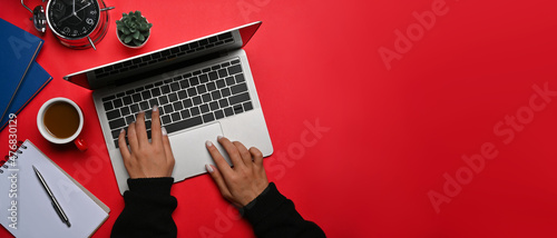 Above view creative woman using computer laptop on red background.