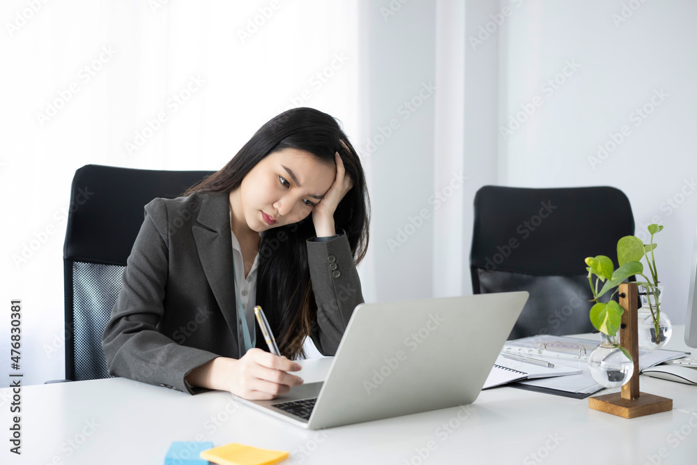 Bored young businesswoman sitting in the office and working with laptop. Bored young businesswoman sitting in the office and working with laptop.