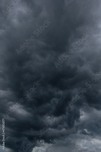 The dark sky with heavy clouds converging and a violent storm before the rain.Bad or moody weather sky and environment. carbon dioxide emissions, greenhouse effect, global warming, climate change.