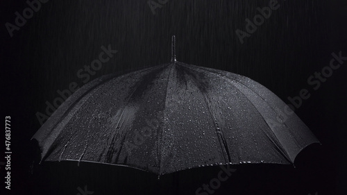 Canvas Photo of the black umbrella and rainy drops on black background