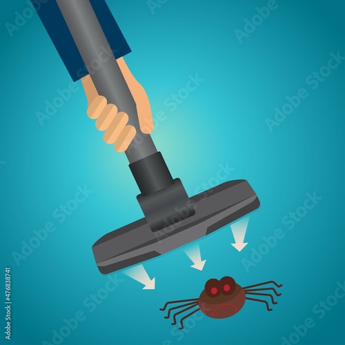Hand of a person holding the vacuum cleaner sucking up a spider