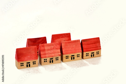 Six red roofed toy houses in two rows on white background
