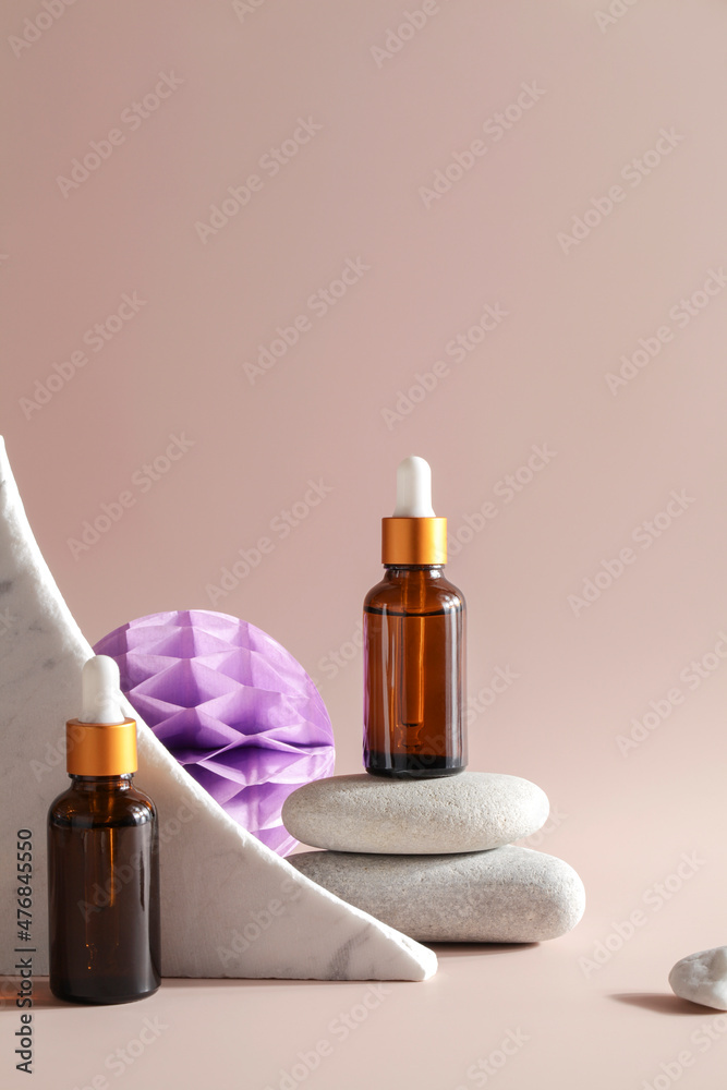 dark amber glass bottles with oil on natural stone on beige background. natural cosmetics product, beauty and presentation concept , mock up dark amber glass bottles with oil on natural stone on beige background. natural cosmetics product, beauty and presentation concept , mock up