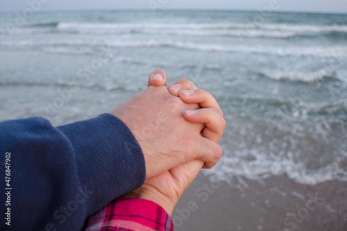 Couple in love holding hands by the sea on their honeymoon