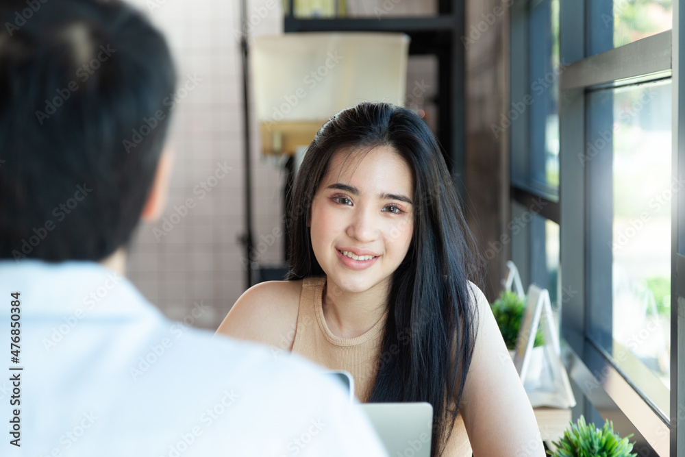 Portrait view over businessman's shoulder to smiling woman looking camera at modern coffee shop. Relax and Life style shot. Portrait view over businessman's shoulder to smiling woman looking camera at modern coffee shop. Relax and Life style shot.