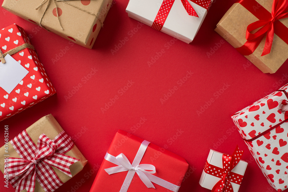 Obraz premium Top view photo of saint valentine's day decorations different gift boxes on isolated red background with copyspace in the middle