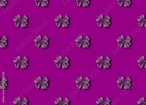 A bow for decorating gifts, painted in purple Velvet Violet. Beautifully tied bow. Photo of a gift package with a seamless pattern.