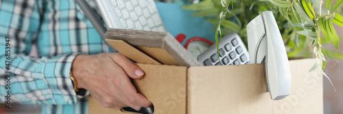 Employee trainee holds cardboard box with things closeup photo