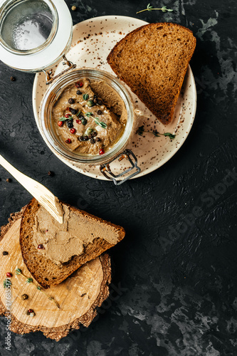 Toast with pate or mousse. homemade chicken liver pate in a glass jar, vertical image. top view. place for text