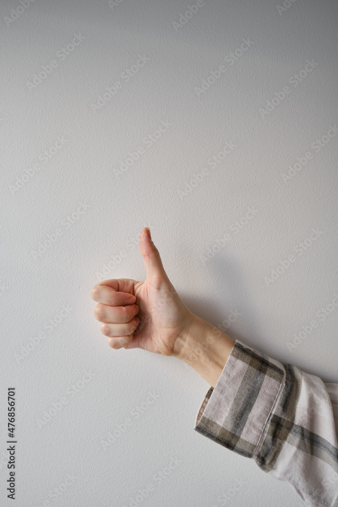 Female hand showing thumbs up gesture showing ok or Excellent on light background. Gestures. Emotions Female hand showing thumbs up gesture showing ok or Excellent on light background. Gestures. Emotions