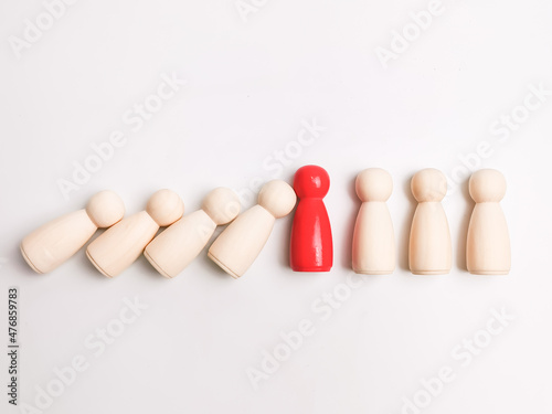 Wooden figures falling to red figure stopping domino effect. © Ekahardiwito