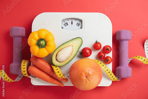Flat lay composition with scales and healthy food on red background