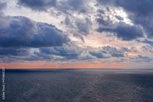 Early morning sunrise over the sea . Some clouds.