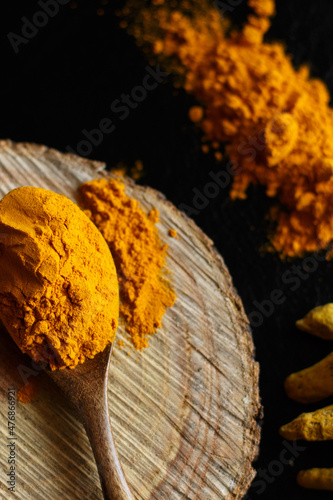 Dry ground curcuma turmeric indian seasoning for medicine on wood