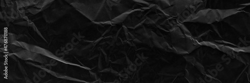 Black crumpled paper texture with folds banner. Black grunge surface. Black wallpaper background. 