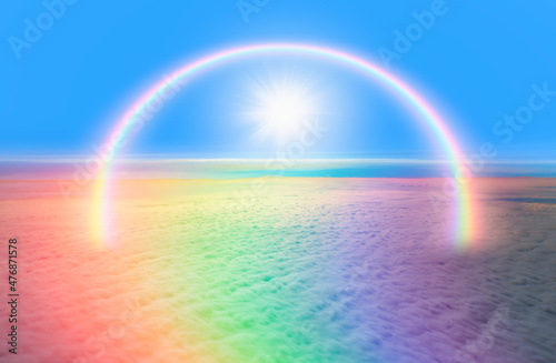 The sun shines on the sky with amazing rainbow over the clouds. Fantastic background