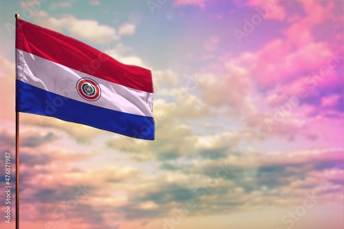 Fluttering Paraguay flag mockup with the space for your content on colorful cloudy sky background.